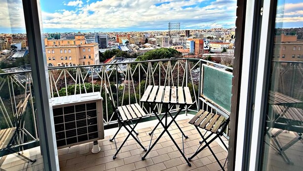 A balcony with a view of a cityscape, including buildings and a clear sky. - GarbaStop (Rome)