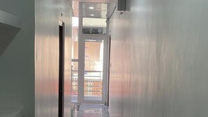 Ein Korridor mit glänzendem, spiegelndem Boden und einer Decke mit eingelassener Beleuchtung.