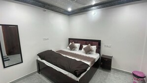 Ein Schlafzimmer mit Bett, Nachttischen, einem Spiegel und einem kleinen Schrank.