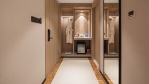 Een hotelgang met houten wanden, een spiegelkast en een kleine koelkast.