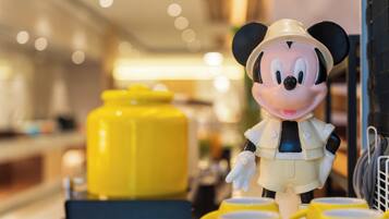 A figurine of a character in a safari outfit standing next to yellow mugs.