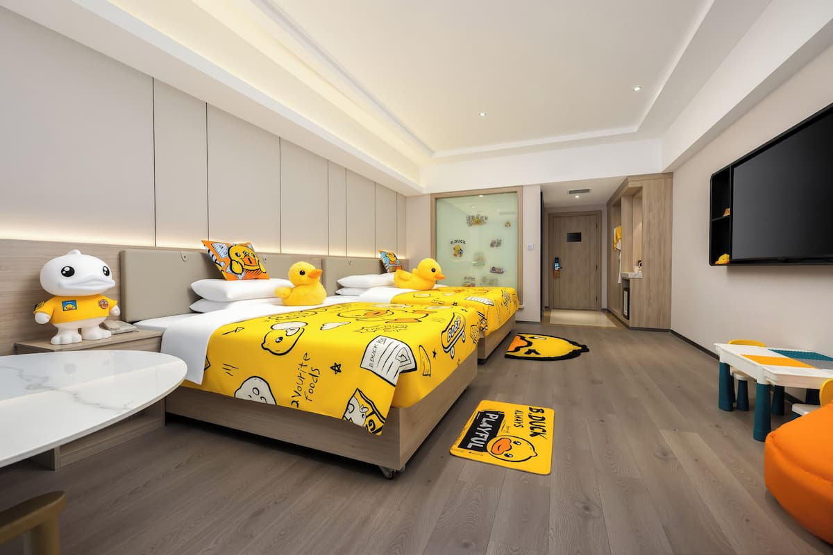 Quarto de hotel moderno com uma cama grande, uma escrivaninha, uma cadeira e uma televisão.
