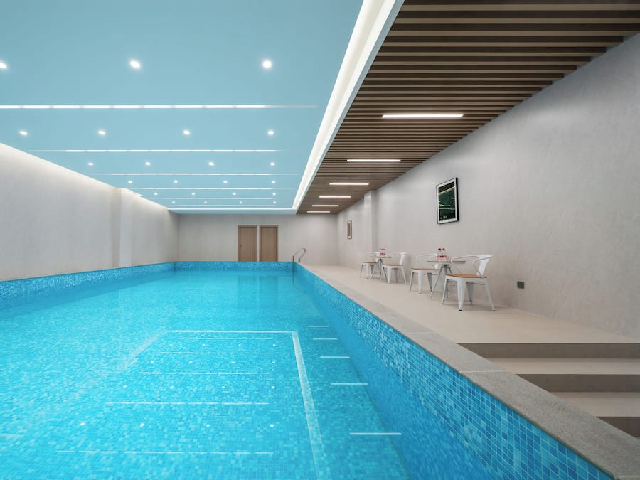 A swimming pool with a tiled floor and a ceiling with recessed lighting.