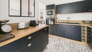 Een moderne keuken met donkere kastjes, een houten aanrecht, een roestvrijstalen spoelbak en een magnetron.