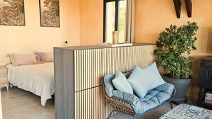 A modern living room with a sofa, a chair, a coffee table, and a potted plant. - Que Pour 2, Cottage/studio Le Bonheur, 1-bedroom with swimming pool and AC  Gers (Mauroux)