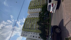 Un immeuble résidentiel à plusieurs étages, doté d’une architecture moderne, de balcons et d’un toit plat.