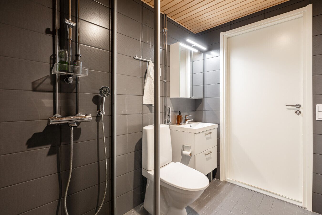 Un baño moderno con ducha, inodoro y lavamanos.