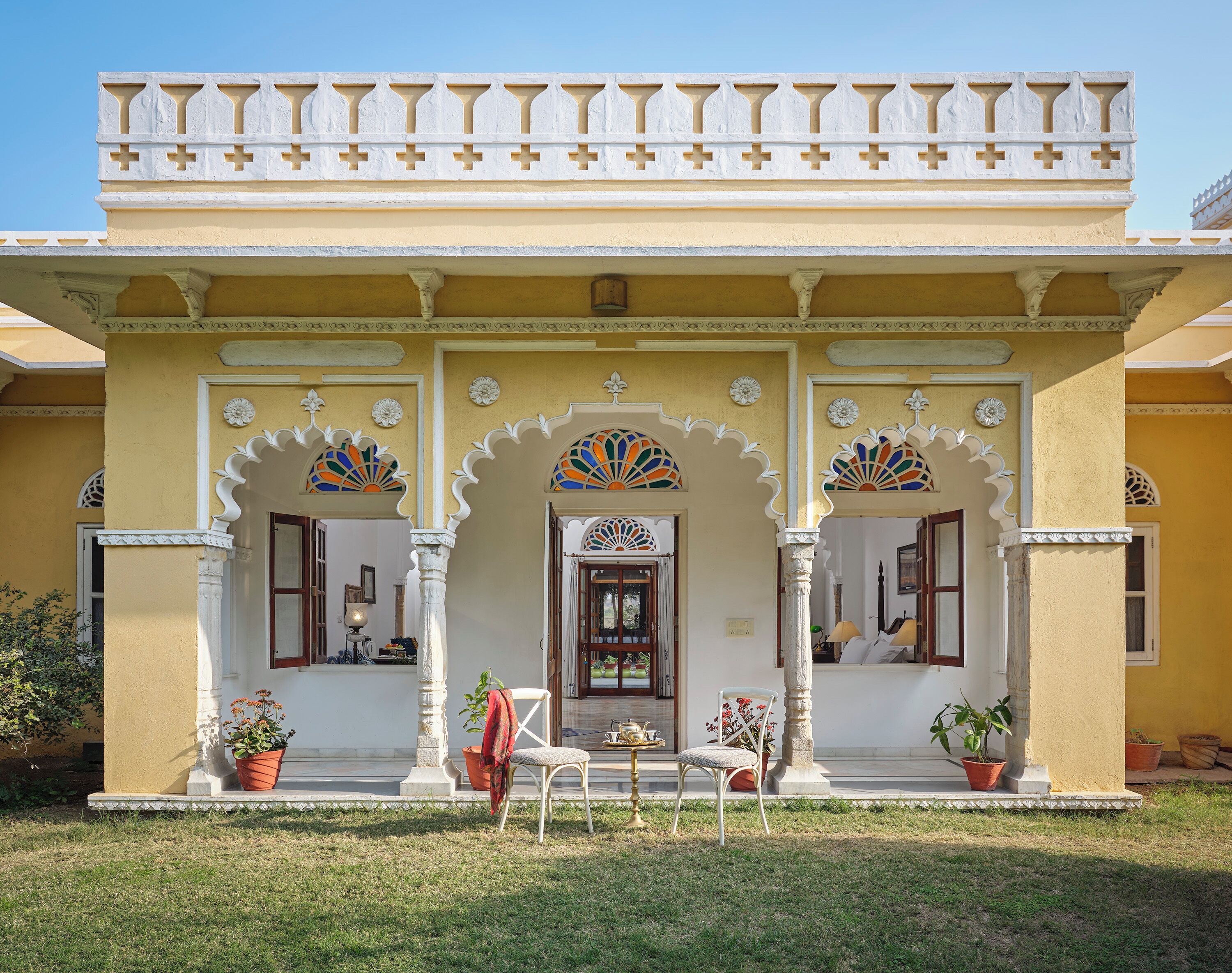 Ein traditionelles Gebäude mit einer gelben Fassade, verzierten Bögen und einem Balkon mit Geländern.