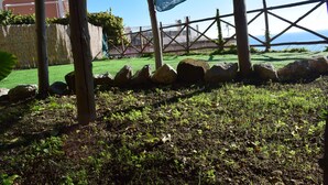 Un espace jardin agrémenté d’une clôture en bois, de rochers et d’une pelouse.