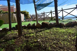 A garden area with a wooden fence, rocks, and a grassy lawn. - La Fiorita: an oasis of peace suspended between the sky and the sea of Positano (Positano)