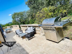An outdoor patio with a built-in grill, seating area, and a view of the surrounding landscape. - House with a Provençal feel - Pool - Tennis - Sports (Évenos)
