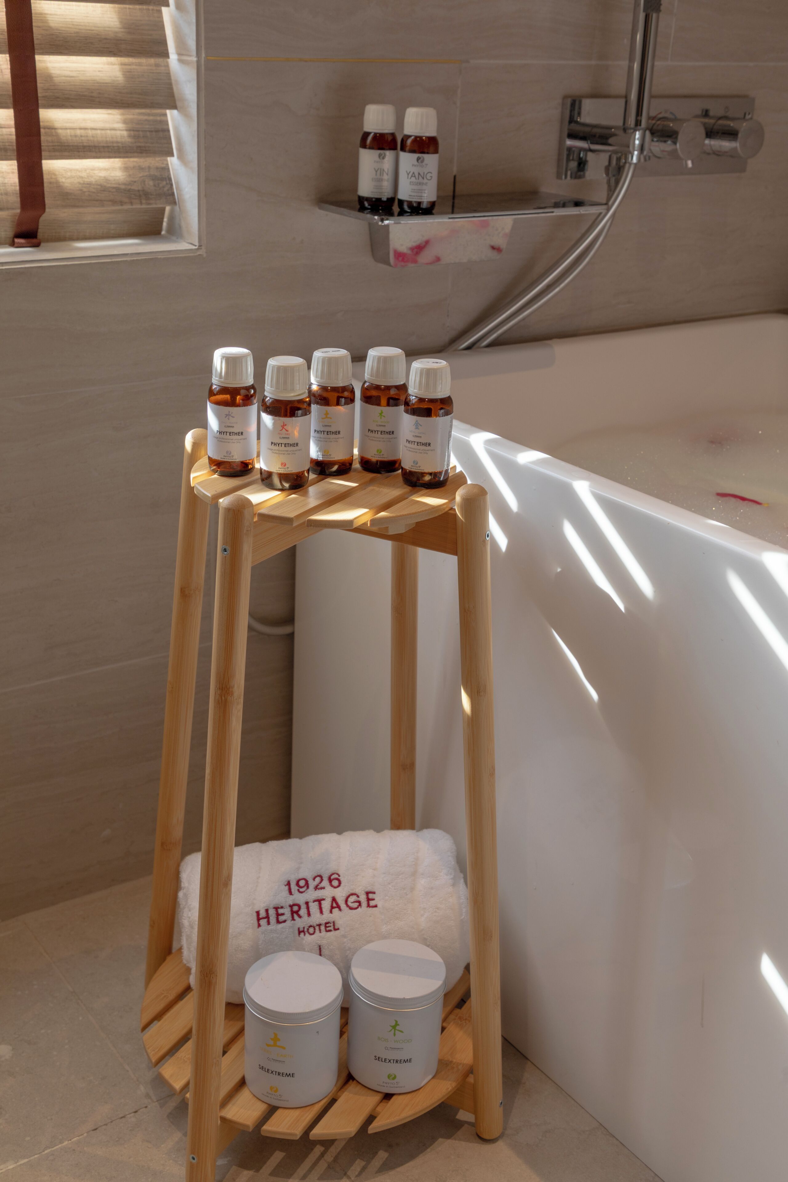 A wooden shelf with bottles and containers in a bathroom setting.