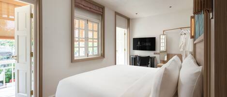 A hotel room with a large bed, a television, a window with a view, and a door leading to an outdoor area.