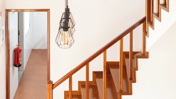 A staircase with wooden railings and a hanging light fixture. - Ermal Green Haven (Vieira do Minho)
