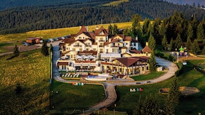 A large hotel with multiple buildings, a swimming pool, and a parking area.