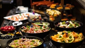 A buffet with various dishes including salads, meats, and desserts.