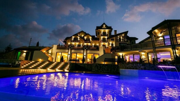 A large, multi-story building with a swimming pool in front.