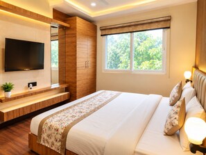 Une chambre moderne avec un grand lit, un téléviseur fixé au mur, une fenêtre donnant sur un paysage verdoyant et des meubles en bois intégrés.