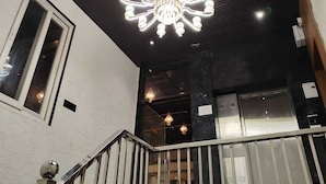 Un interior moderno con una lámpara original, una escalera y vistas al exterior.