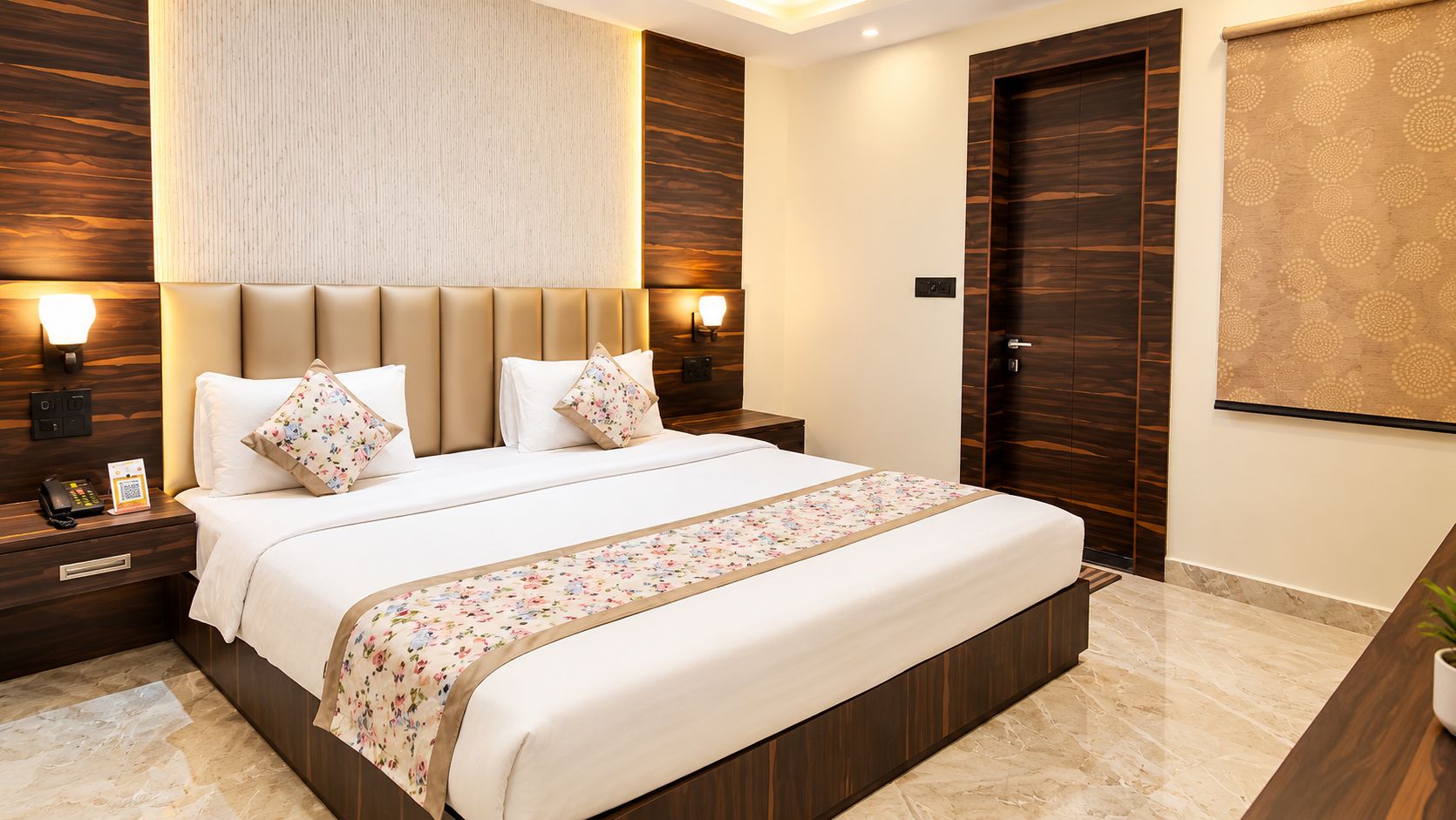 A modern hotel room with a large bed, nightstands, and a wall-mounted lamp.