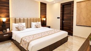 A modern hotel room with a large bed, nightstands, and a wall-mounted lamp. - SHRI GAURANAG PALACE  (Vrindavan)