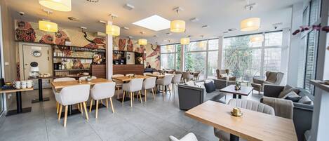 A modern restaurant with multiple dining areas, including a bar and seating with a view of the outdoors.