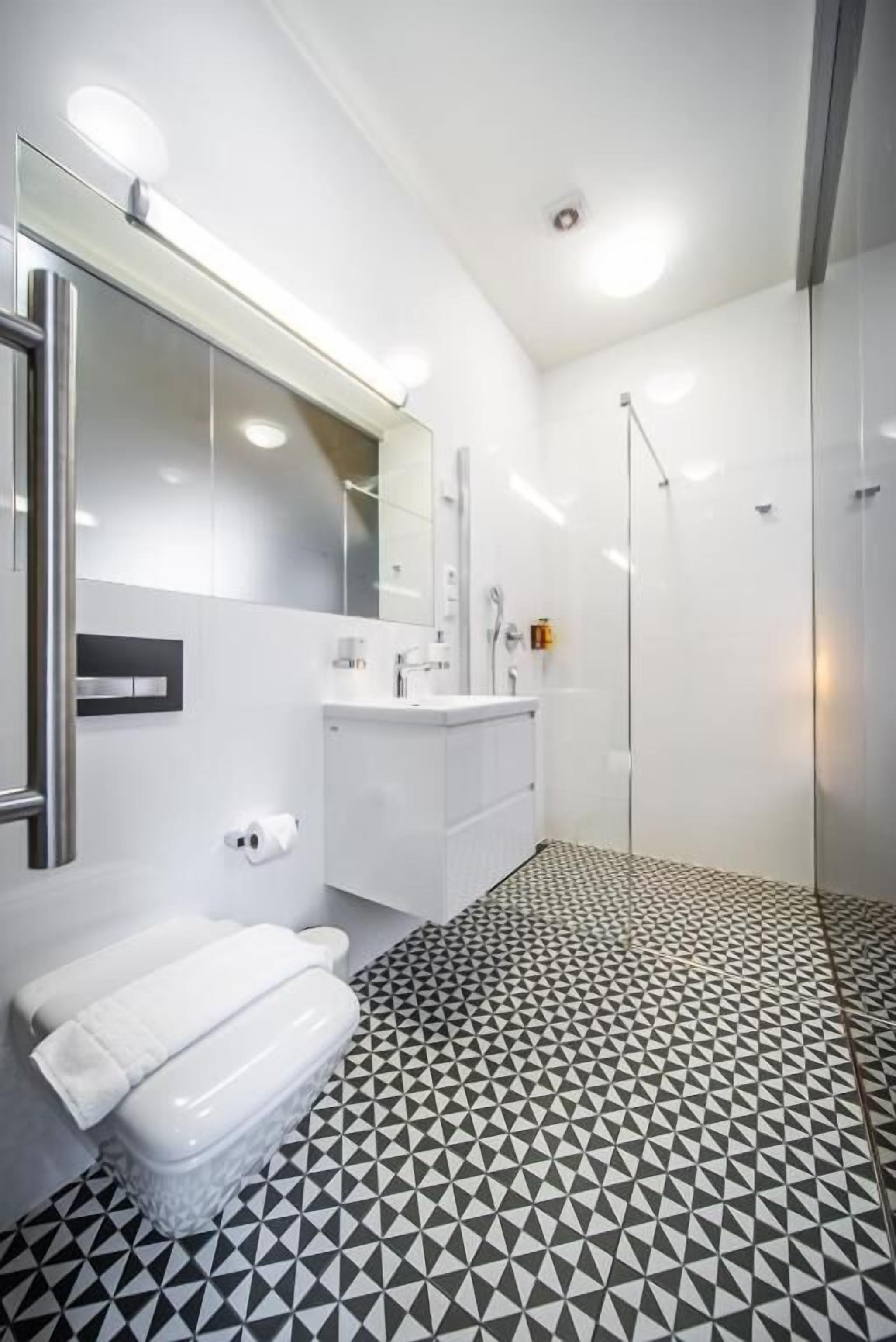 Un baño moderno con inodoro, lavabo y ducha.