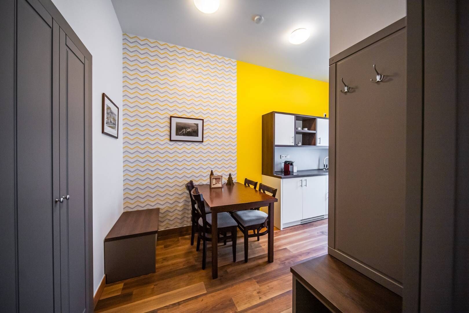 A compact kitchen with white cabinets and a wooden dining table.