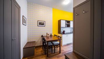 A compact kitchen with white cabinets and a wooden dining table.