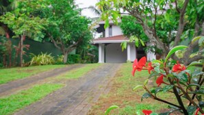 A pathway leading to a house surrounded by lush greenery. - Villa Amora Hikkaduwa (Hikkaduwa)