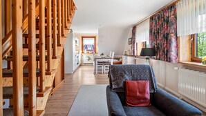 Et moderne interiør med trappe, spiseplads og stue med sofa.