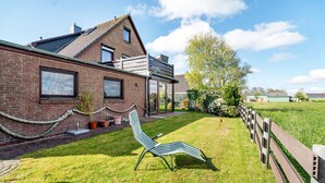Et hus med murstensfacade, skråt tag og en overdækket terrasse.