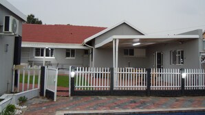A residential property with a swimming pool, a covered patio, and a fenced yard. - Daeka Guesthouse (Kempton Park)