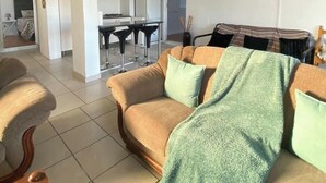Una sala de estar con sofá, una mesa de centro y un comedor con mesa y sillas.