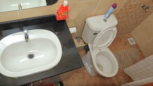 Un baño con lavamanos, inodoro y espejo.