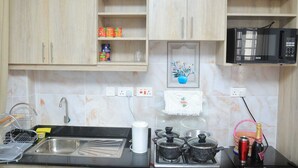 Una cocina con armarios de madera, un microondas, un fregadero y una estufa.