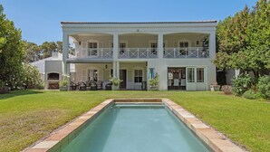 Una casa de dos plantas con piscina delantera.