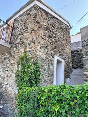 A stone building with a balcony, a staircase, and a door. - CAP Hélios, L'écrin Corse.  Breathtaking sea and pool views (Morsiglia)