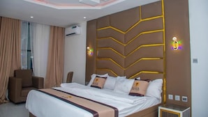 Een moderne hotelkamer met een groot bed, een sofa en uitzicht op de stad.