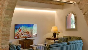 A room with a brick archway, a sofa set, a painting, a lamp, and a window. - Villa Casale Enrica con Piscina Bio Lago (Roccastrada)