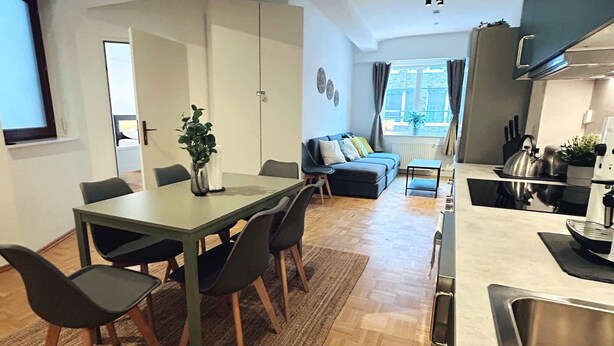 Un apartament modern amb zona de menjador, cuina i saló.