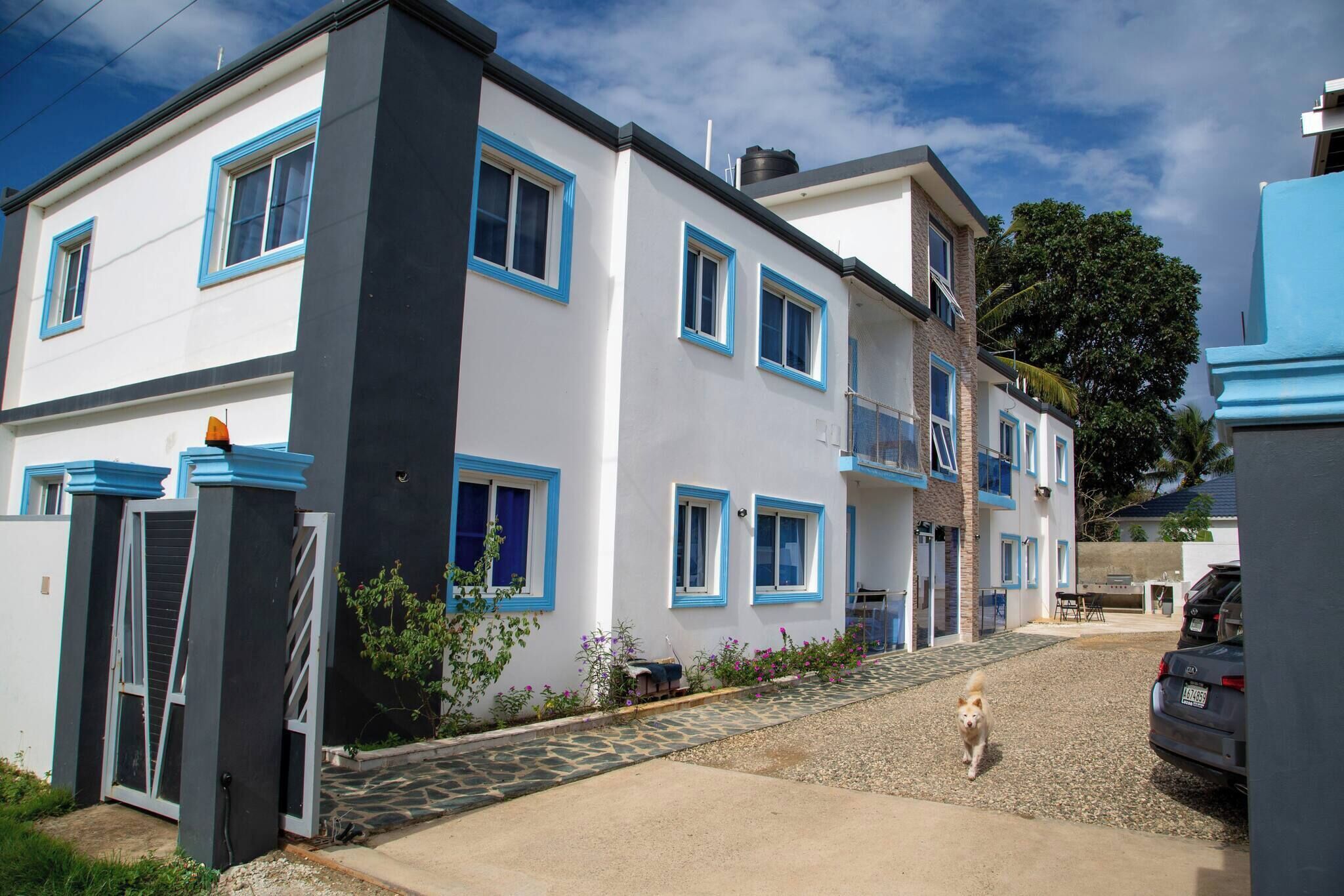 A multi-story residential building with a white facade and blue trim.