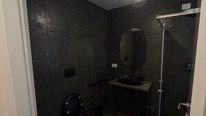 A modern bathroom with a toilet, bidet, and a glass-enclosed shower. - ROOMS 78 (Castel di Sangro)