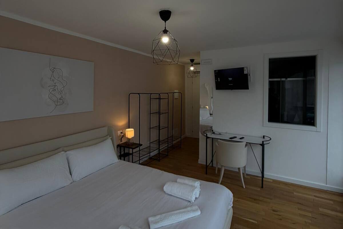 Une chambre d’hôtel moderne, dotée d’un grand lit, d’un bureau et d’une télévision.