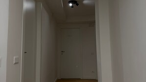 A narrow hallway with wooden flooring and white walls. - ROOMS 78 (Castel di Sangro)