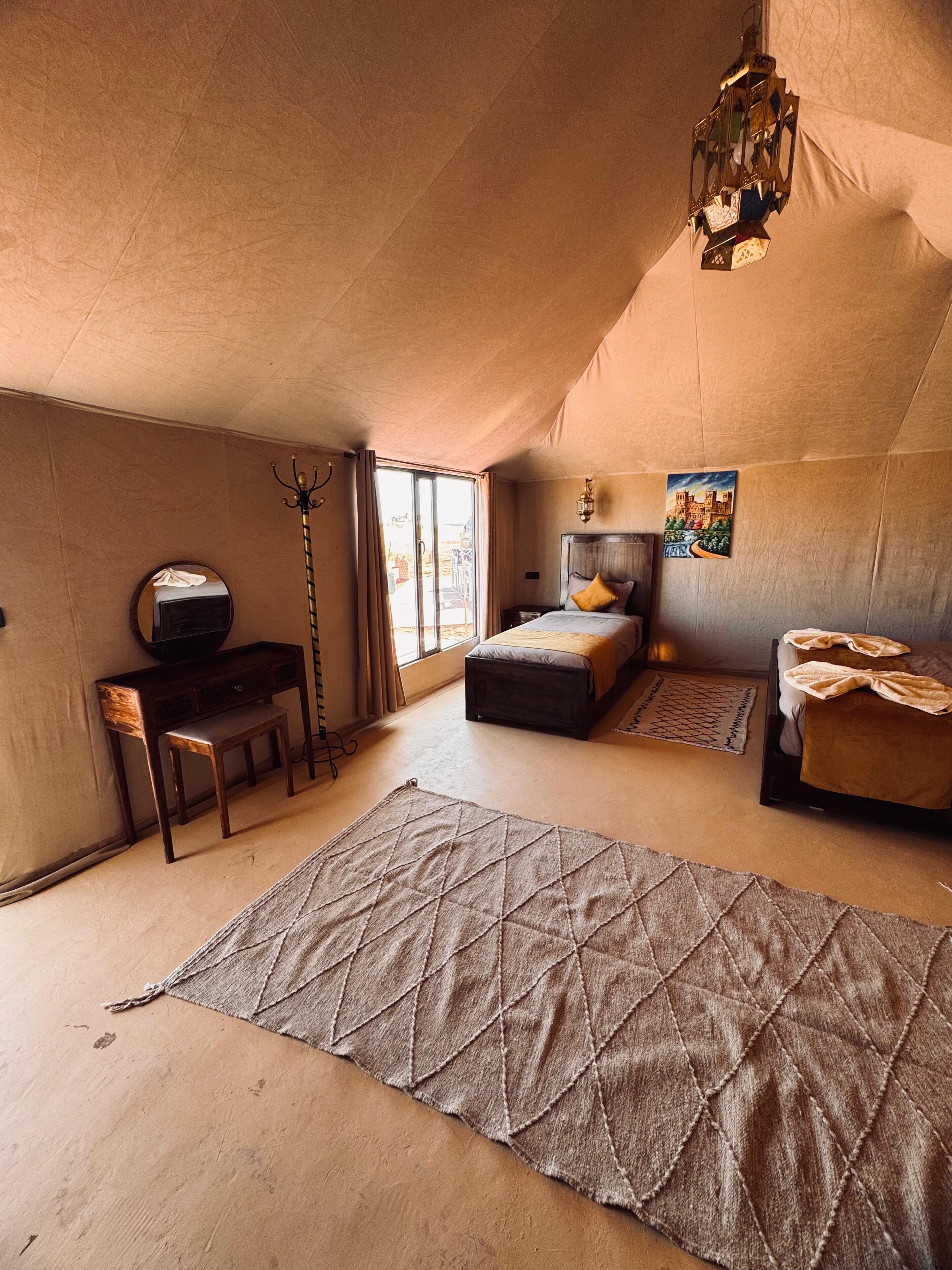 Un dormitorio acogedor en el ático, con cama, escritorio y un tapete grande.