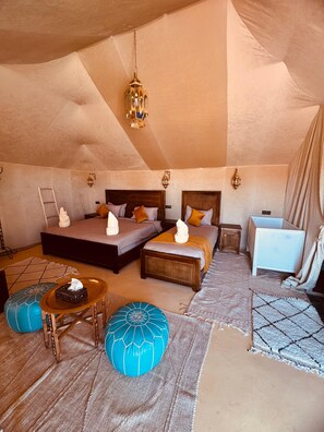 Une chambre confortable avec deux lits, une petite table de chevet, un berceau et une lanterne suspendue.