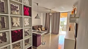 A modern living room with a sofa, a coffee table, and a decorative wall with glass panels. - Nicpa atico Los Cristianos (Los Cristianos)