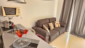 A modern living room with a sofa, a coffee table with drinks, a lamp, and a radio. - Nicpa atico Los Cristianos (Los Cristianos)
