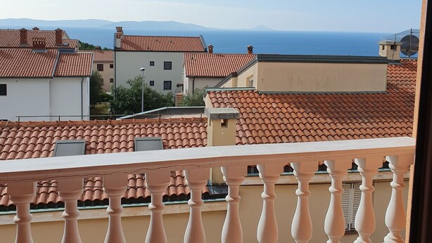 A balcony with a view of terracotta-roofed buildings and the sea. - 4-Star Comfort Apartment with Ocean View, Rabac, Croatia (Rabac)